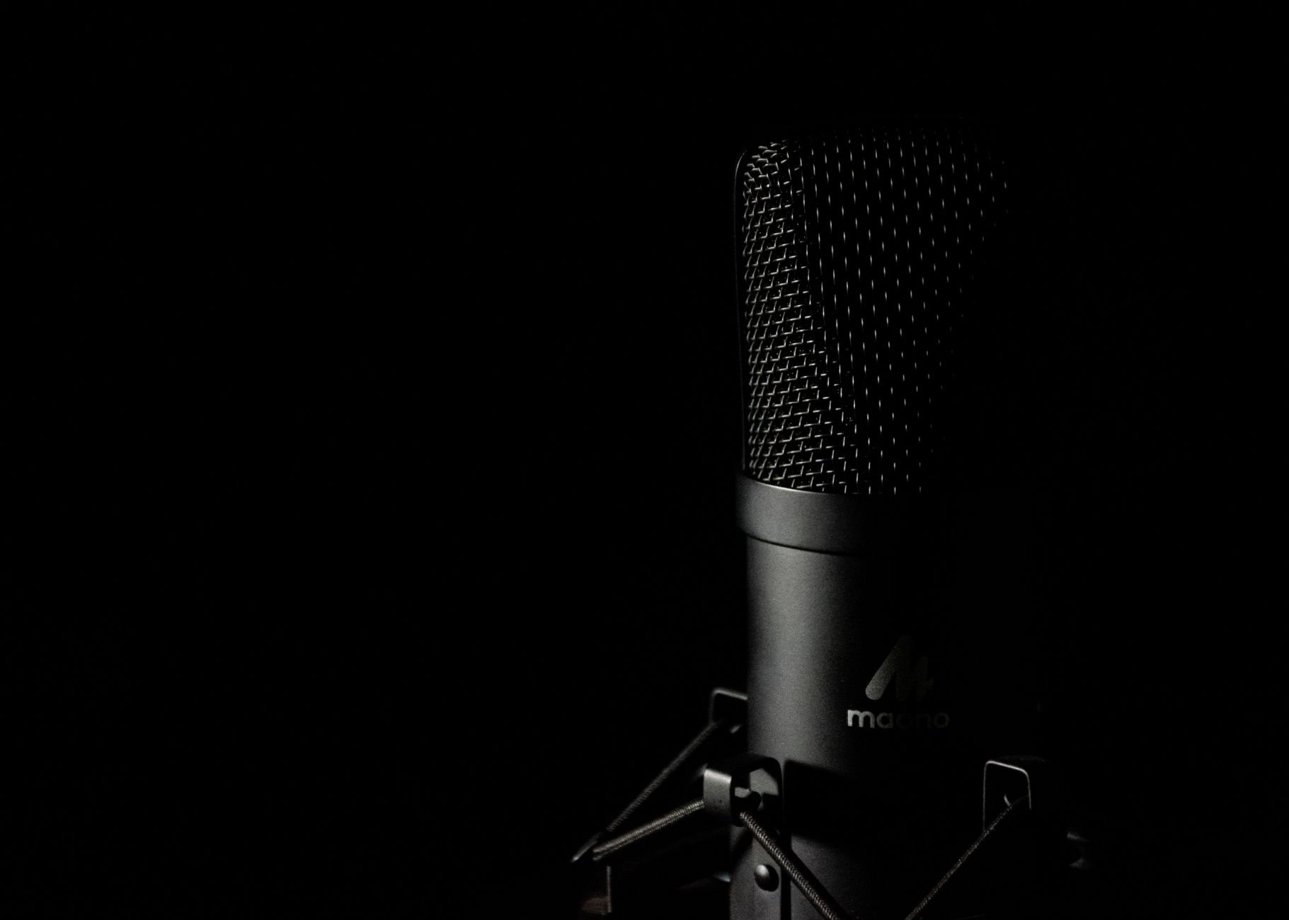 Studio microphone close-up with dark moody background for audio production