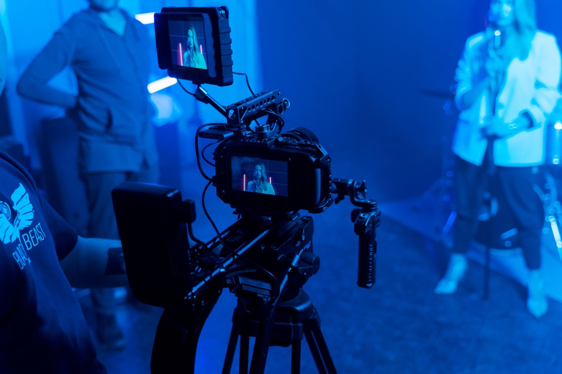 Behind the scenes of a music video recording with professional film equipment and studio lighting
